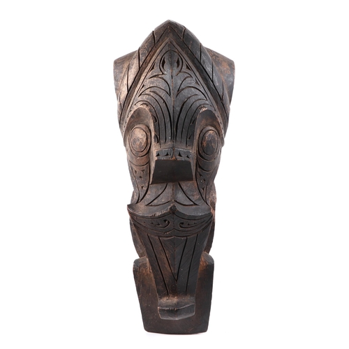 324 - A pair of oceanic hardwood carved corbels, depicting stylised faces, 47cm high.