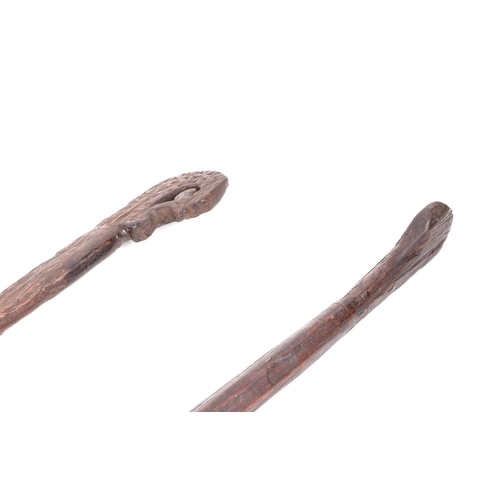 325 - Two carved hardwood shoulder yokes, possibly Indonesian, 135cm and 134cm long (2).