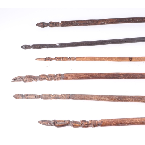 326 - A group of six African ceremonial dance wands, with figural terminals, largest 119cm long (6).