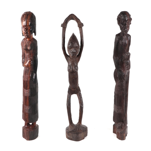 334 - An African carved hardwood female fertility figure, 62cm high, a man holding a staff, 62 cm high, an... 