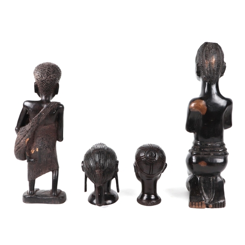 335 - An African Tribal carved hardwood fertility figure of a woman holding a baby, 37cm high, a women hol... 