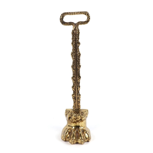 370 - A brass lion paw door porter/door stop, 37cm high.