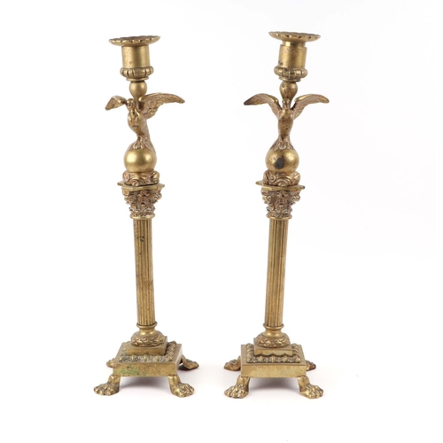 392 - A pair of French brass Empire style candlesticks with eagle perched on bull sconces, Corinthian colu... 