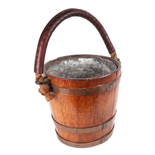 397 - A 19th century copper bound oak peat or fire bucket, with Royal Coat of Arms and original leather bo... 