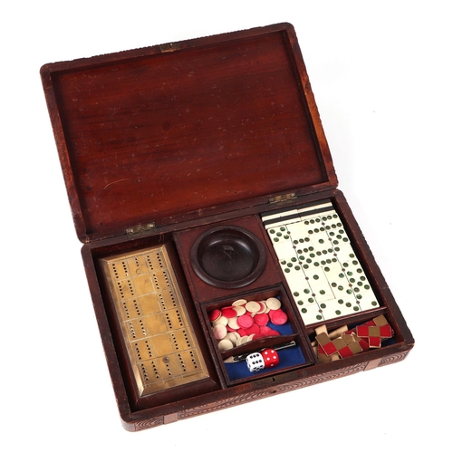 398 - A Black Forest carved wooden games compendium incorporating dominoes, cribbage board, dice, counters... 