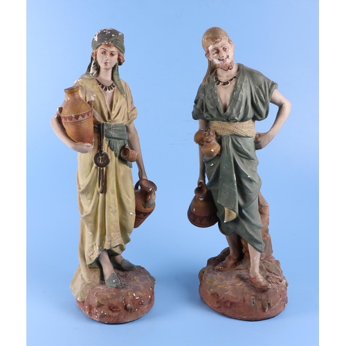 407 - A pair of late 19th / early 20th century plaster figures of water sellers, each 51cm high.