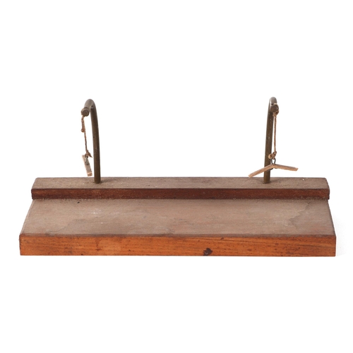 412 - A teak scale model of a rowing boat, 30cm long, mounted on a brass and wooden stand.