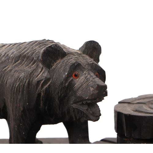 414 - A Black Forest carved wood pen and ink stand, having a bear flanked by two ink wells and pen dish, 2... 