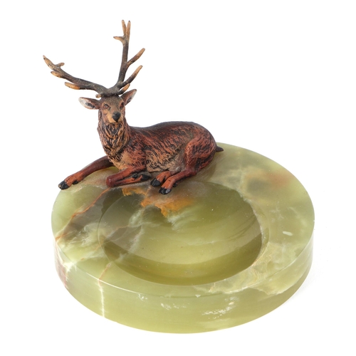 418 - An early 20th century cold painted bronze figure of a red deer, on a green onyx ashtray base, 12cm d... 