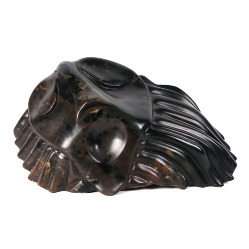 449 - A 20th century soapstone carving depicting a stylised face with flowing hair, 33cm wide.