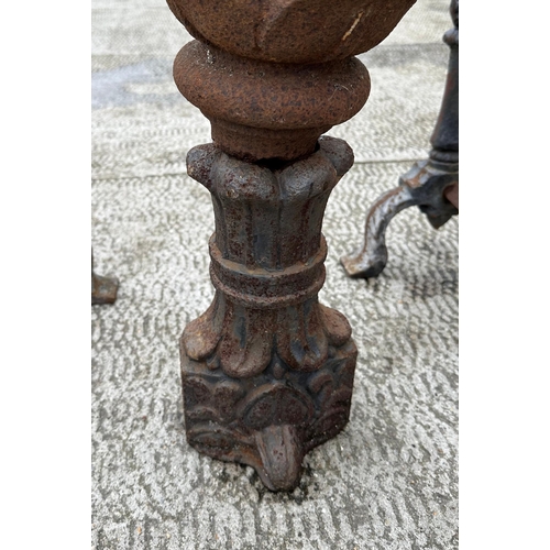 47 - A cast iron pineapple form finial, 54cm high, together with a pair of fire dogs (3).