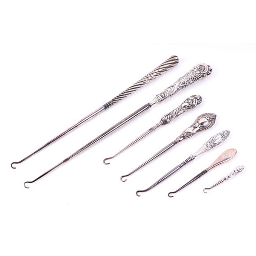 506 - A boxed silver handled shoe horn and button hook set, together with a group of silver handled button... 