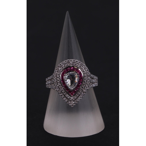 519 - An 18ct white gold ring set with a large pear-shaped rose cut diamond, within a calibre rubies and a... 