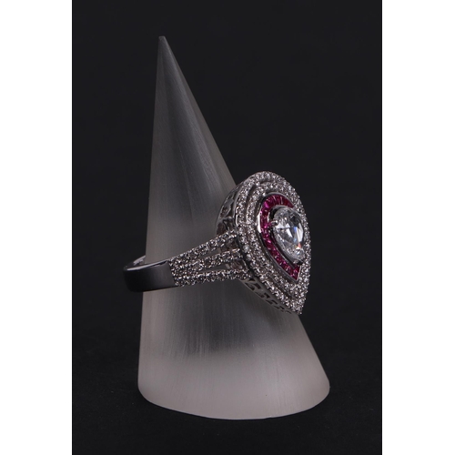 519 - An 18ct white gold ring set with a large pear-shaped rose cut diamond, within a calibre rubies and a... 