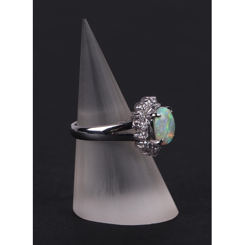 521 - A platinum ring, set with an oval opal cabochon, within a halo of diamonds, opal approx 1.05ct, appr... 