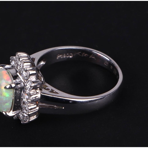 521 - A platinum ring, set with an oval opal cabochon, within a halo of diamonds, opal approx 1.05ct, appr... 