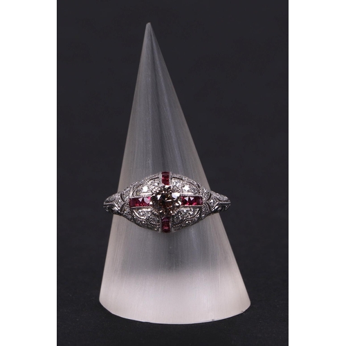 538 - An art deco style platinum ring, set with a central diamond calibre cut rubies and further diamonds,... 