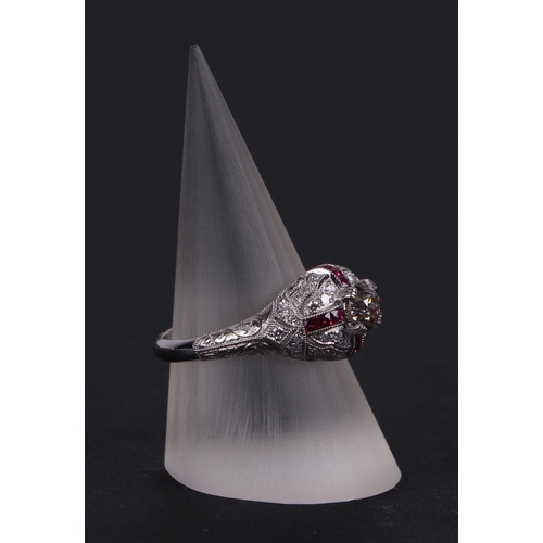 538 - An art deco style platinum ring, set with a central diamond calibre cut rubies and further diamonds,... 