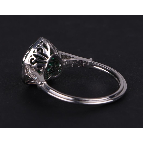 539 - A platinum ring set with a heart shaped emerald, surround by calibre cut emeralds and diamond set sh... 