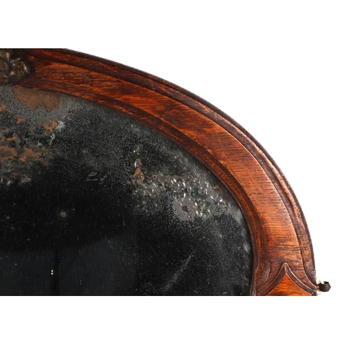 827 - An Arts and Crafts style carved oak oval wall mirror with oval bevelled plate, 71cm wide.