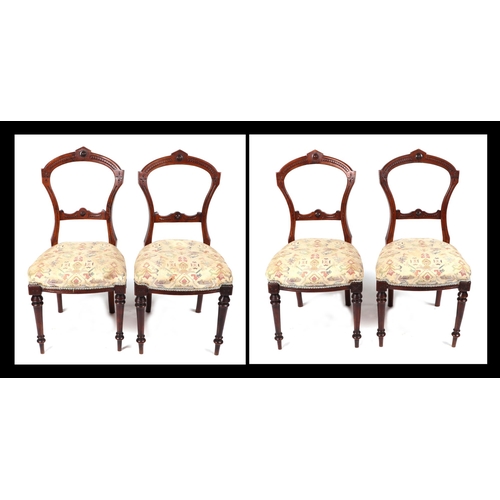 831 - A set of four Victorian walnut balloon back chairs with upholstered seat on turned front supports. (... 