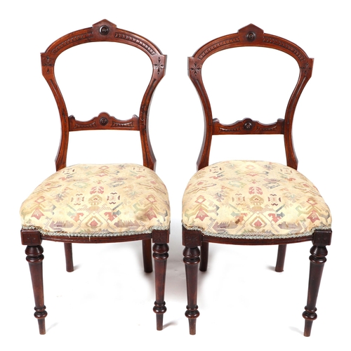 831 - A set of four Victorian walnut balloon back chairs with upholstered seat on turned front supports. (... 