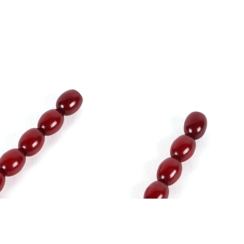 541 - A graduated string of cherry amber like  Bakelite beads, approx 50cm long, largest bead 10mm long, 1... 