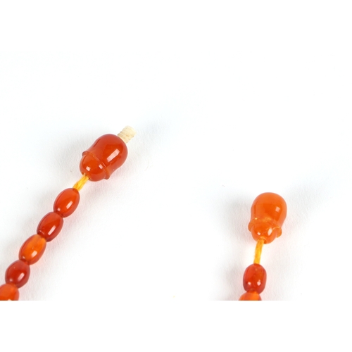 541 - A graduated string of cherry amber like  Bakelite beads, approx 50cm long, largest bead 10mm long, 1... 