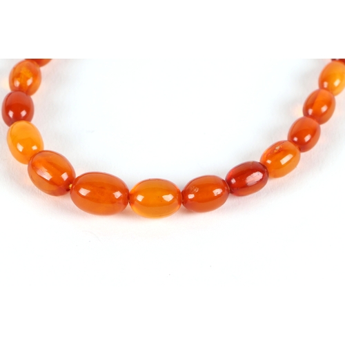 541 - A graduated string of cherry amber like  Bakelite beads, approx 50cm long, largest bead 10mm long, 1... 