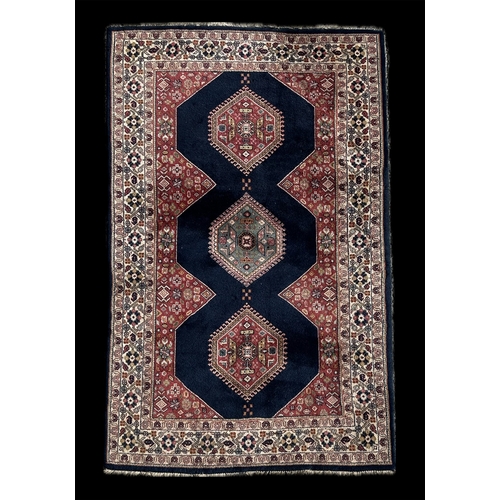 152 - A Caucasian rug with three central medallions within a multi border, on a blue ground, 190 by 122cm.