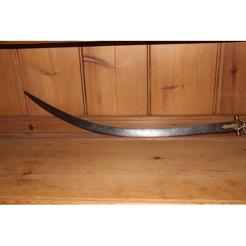 86 - An Indian tulwar sword, with curved steel blade and brass handle, 82cm long.