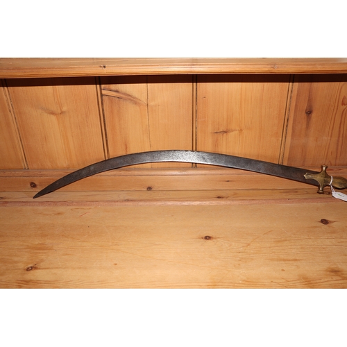 86 - An Indian tulwar sword, with curved steel blade and brass handle, 82cm long.