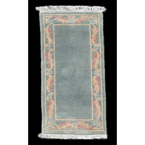133 - A Chinese rug, with pale green ground, and floral boarder, 142 by 68cm.