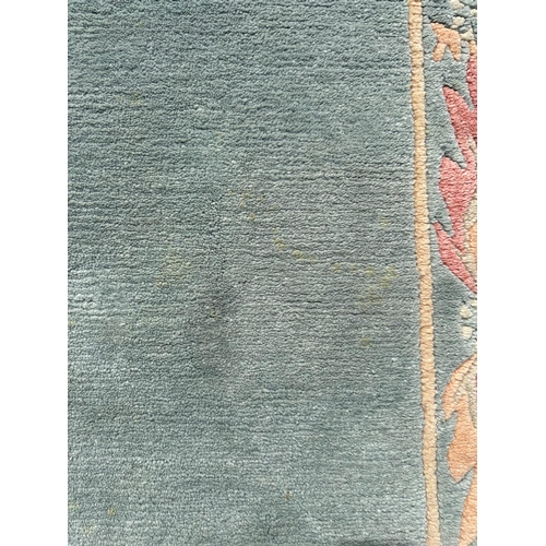 133 - A Chinese rug, with pale green ground, and floral boarder, 142 by 68cm.