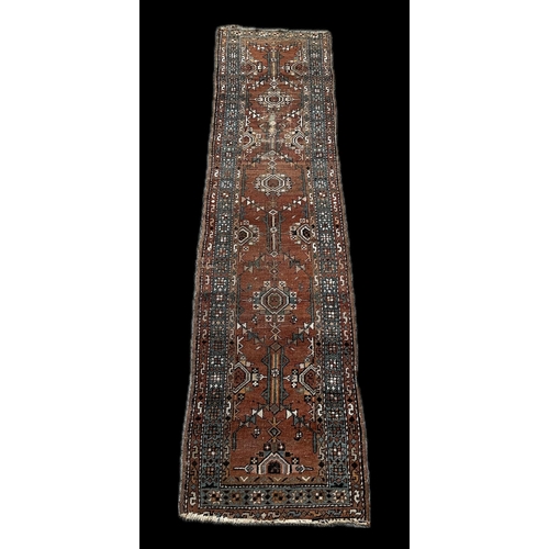 135 - A Persian runner, repeating geometric motifs, on an orange ground, within a geometric multi boarder,... 