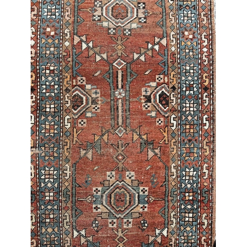 135 - A Persian runner, repeating geometric motifs, on an orange ground, within a geometric multi boarder,... 