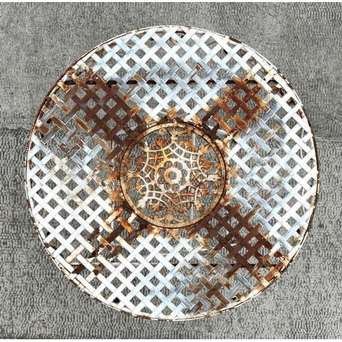 21 - A folding circular white painted metal garden table, with lattice work top, 69cm diameter.