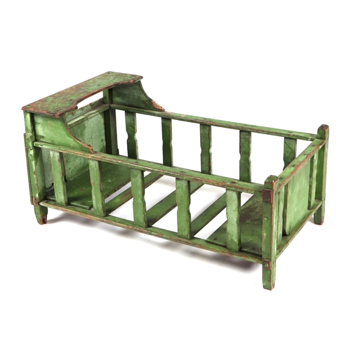 368 - A Folk art miniature gypsy caravan (a/f), 40cm long, together with a green painted dolls cot (2).