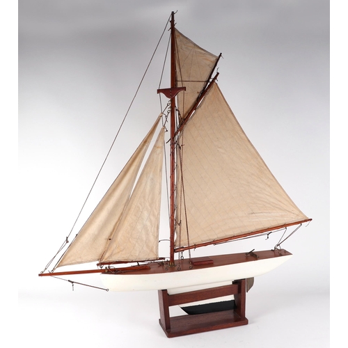 374 - A pond yacht, having a painted hull, 72cm long, mounted on a stand.