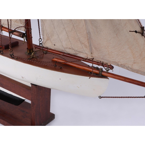 374 - A pond yacht, having a painted hull, 72cm long, mounted on a stand.