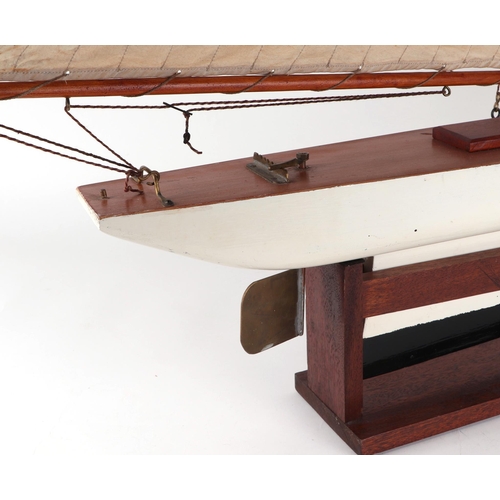 374 - A pond yacht, having a painted hull, 72cm long, mounted on a stand.