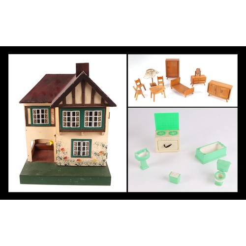 375 - A 1930s Tri-Ang doll's house with a selection of doll's house furniture, 36cm wide.