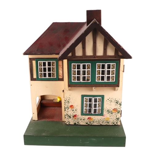 375 - A 1930s Tri-Ang doll's house with a selection of doll's house furniture, 36cm wide.