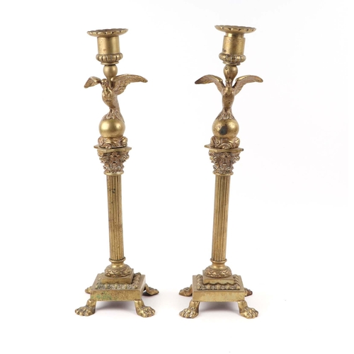 393 - A pair of French brass Empire style candlesticks with eagle perched on bull sconces, Corinthian colu... 
