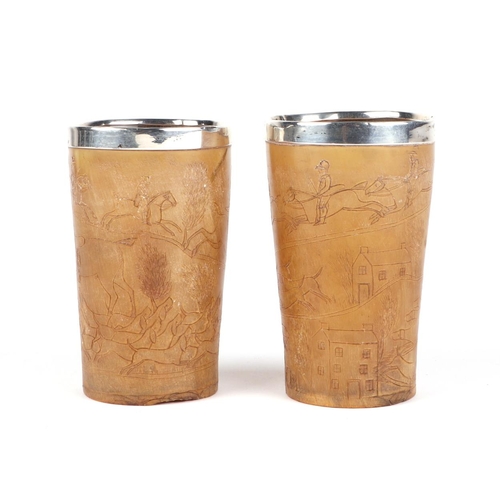 394 - A pair of 19th century carved horn beakers, depicting fox hunting scenes and having silver coloured ... 