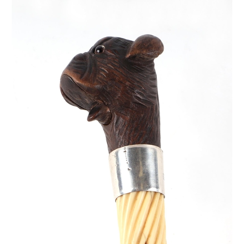 397 - A Victorian ebonised walking cane, with silver collar and ivory section, having a carved soft wood m... 