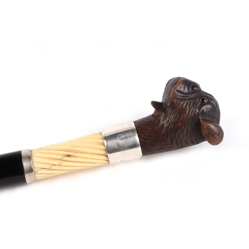 397 - A Victorian ebonised walking cane, with silver collar and ivory section, having a carved soft wood m... 