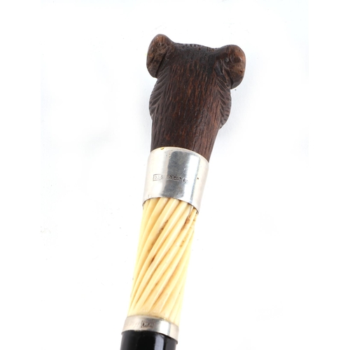 397 - A Victorian ebonised walking cane, with silver collar and ivory section, having a carved soft wood m... 