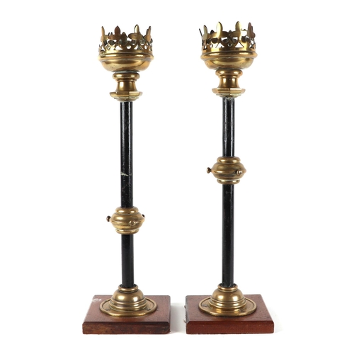 412 - A pair of gothic revival brass and iron candle sticks, on oak bases, 63cm high (2).