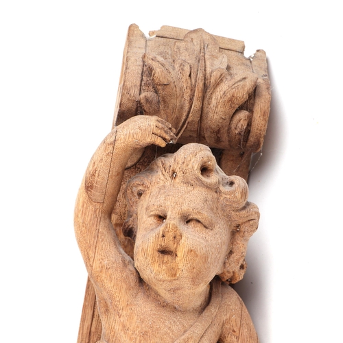 440 - A carved oak corbel, in the form of a putti, possible 18th century, 65cm high, and a pine pineapple ... 